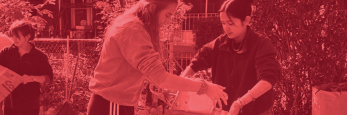 Photo of two girls helping each other, carry a bag. 