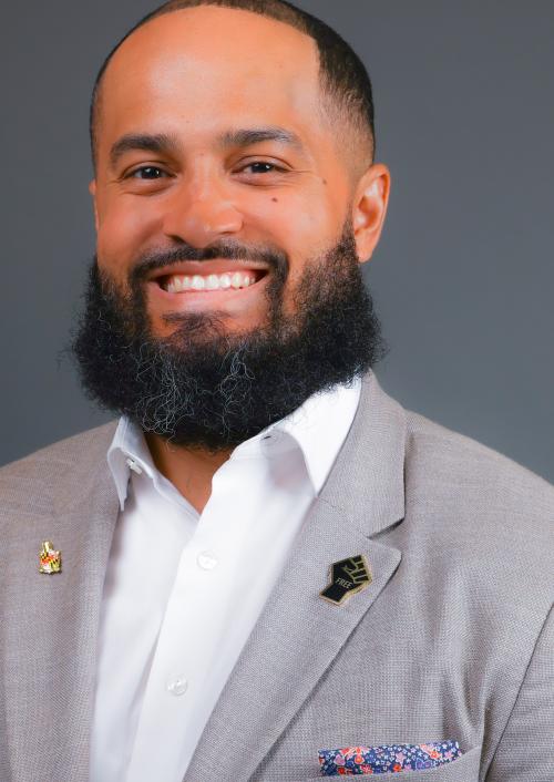 Headshot of Dr. Demar Lewis. Young man with a gray suit and white button down. 