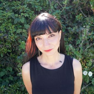 Headshot of Dr. Neda Atanasoski; women in front of a greenery. 